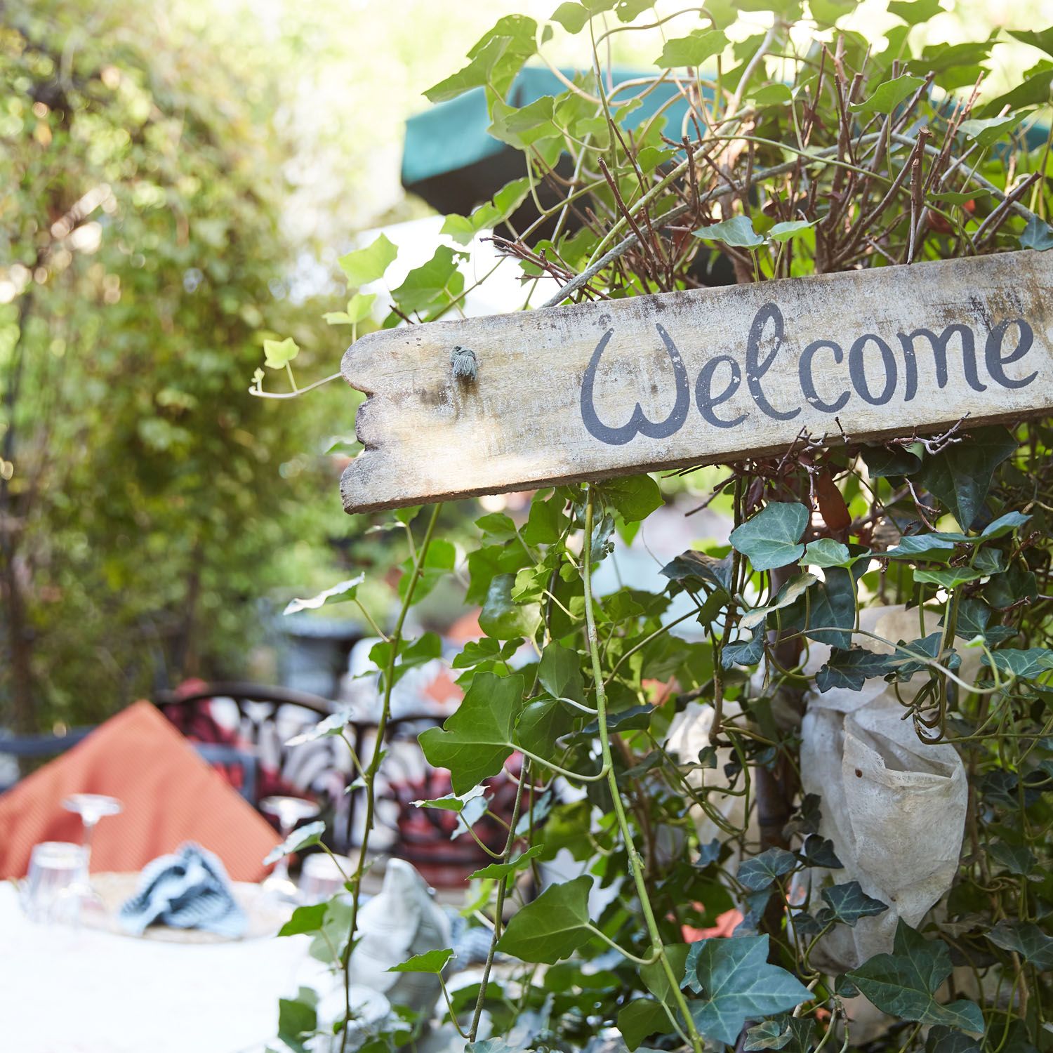 Ein Holzschild mit der Aufschrift «Welcome» im Garten
