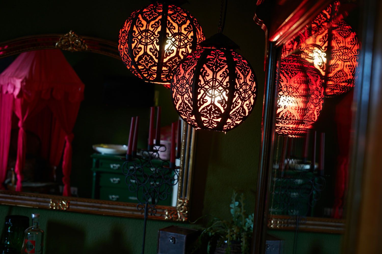 A room with red oriental lanterns and a green writing desk