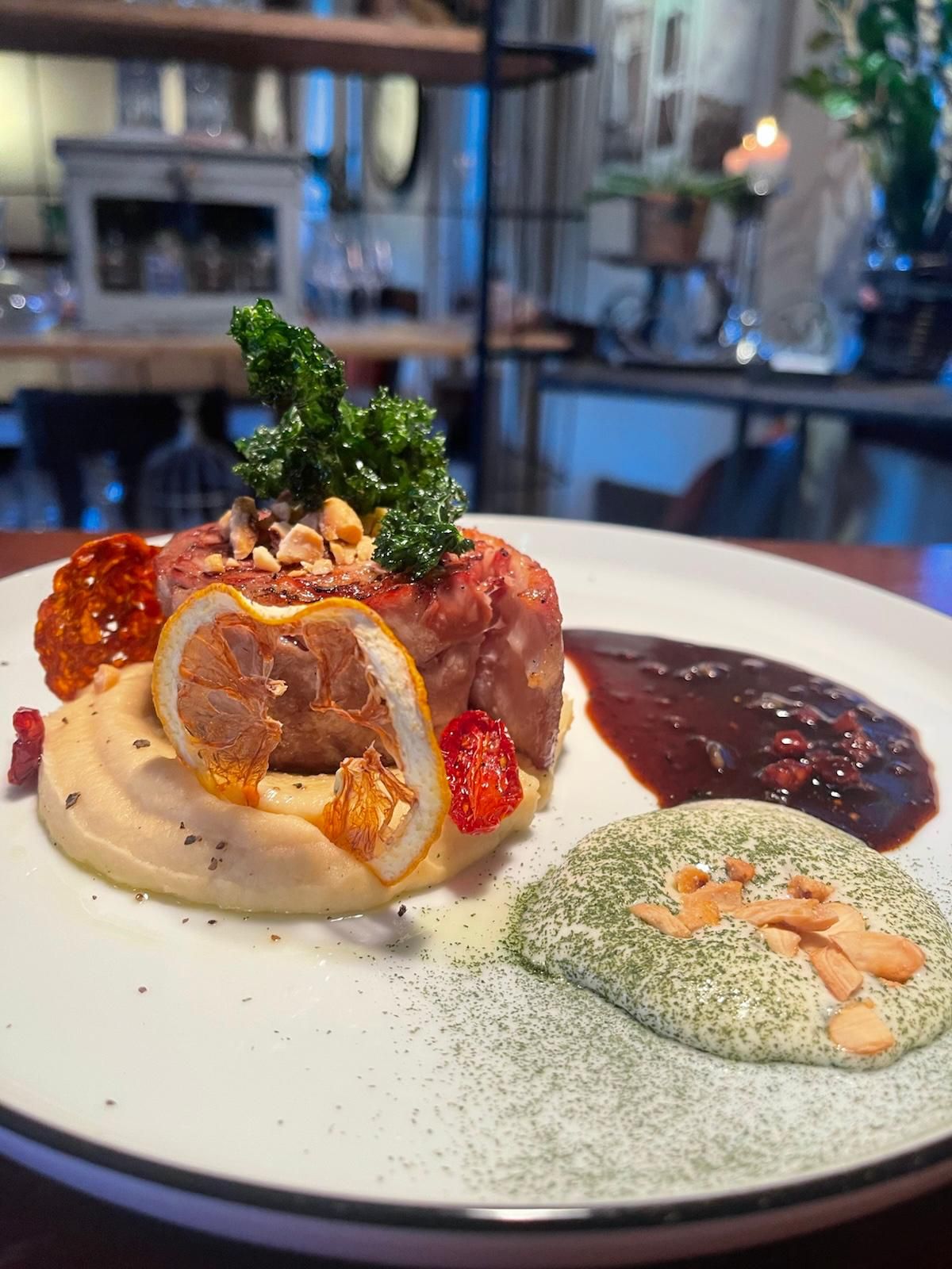 Ein ummanteltes Medaillon auf Püree mit getrockneter Zitrone, Nüssen, dunkler Sauce und Kräutercreme